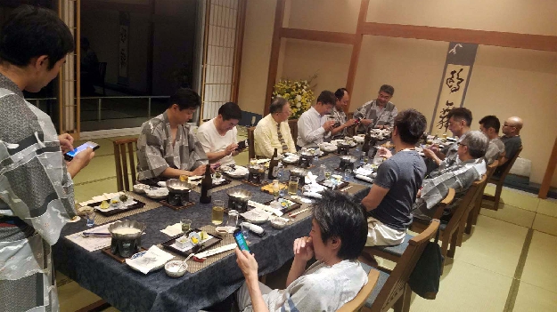 写真１　会食をするメンバー（浴衣の柄に投票中）